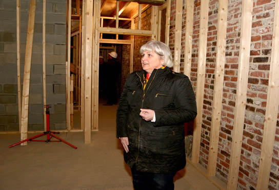 Peggy Phelps of Neighborhood Development Associates plays tour guide Friday at 33 Central Square in Lynn, where lofts are being built.
