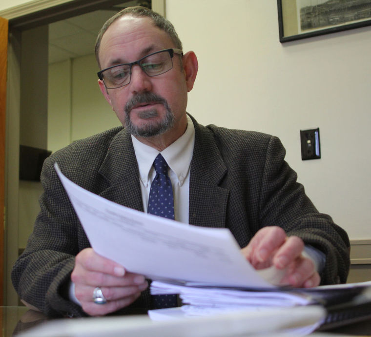 Mike Donovan, the director of Lynn Inspectional Services, thumbs through the Environmental Notification Form for proposed former Genereal Electric gear plant project site.