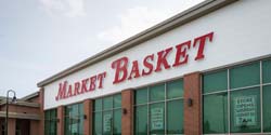 Facade of Market Basket Store with signs in windows depicting the opening date of August 26 at 7 am