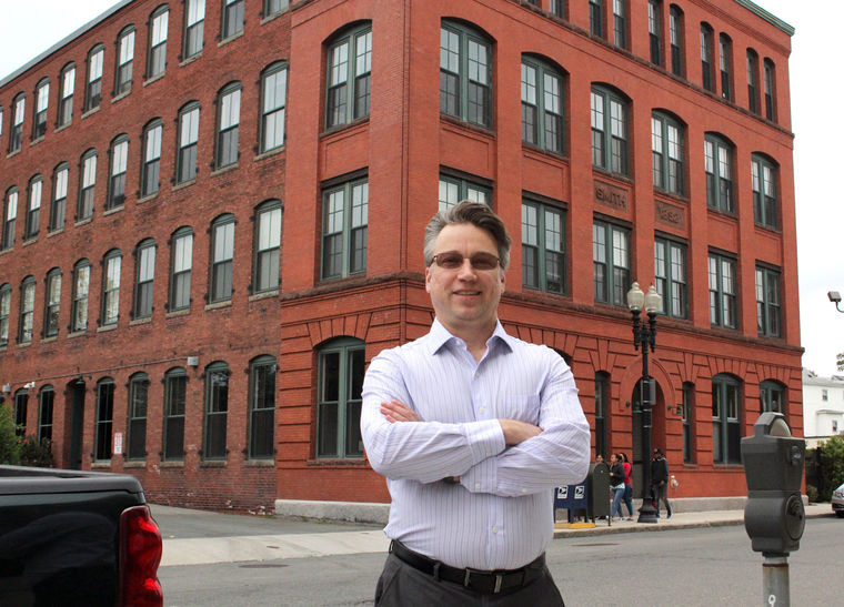 George Herrell stands in front of his home, the Sloan Machinery Lofts on Essex Street in Lynn.