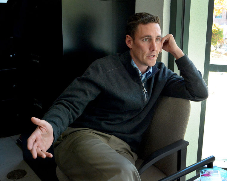 Jason Denocourt sitting in a chair in his new office as Economic Development Director.