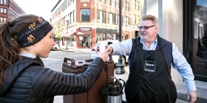 New England Craft Restaurant Concepts CEO Frank Peace hands a coffee to Amy Damon of Lynn as he spreads the word about Brew on the Grid, a new coffeehouse set to open at 30 Willow St. in Lynn