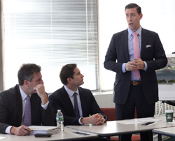 Lynn City Council President Daniel Cahill addresses members of the Lynn Business Partnership at Eastern Bank headquarters on Monday. Jay Ash, state Housing and Economic Development secretary, left, and U.S. Rep. Seth Moulton listen in.