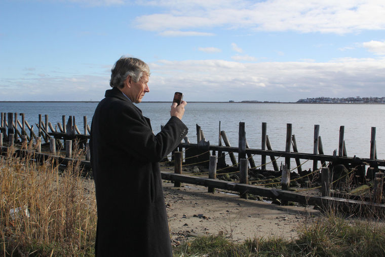 Bob Shuymako, the regional director of planning for HUD, takes note of the sea wall at Hanson Street and Riley Way Monday during his tour of sections of Lynn with the LEAD Team. 